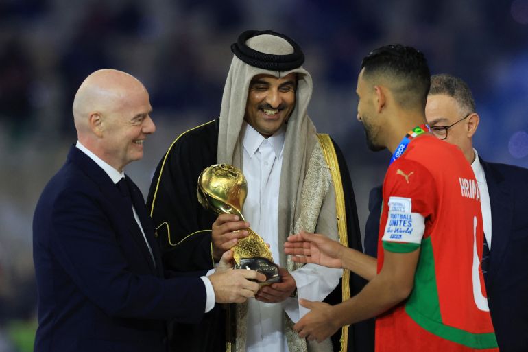 FIFA president Gianni Infantino and Emir of Qatar Sheikh Tamim bin Hamad Al-Thani hands the FIFA Arab Cup trophy to Morocco's Mohamed Hrimat on the podium