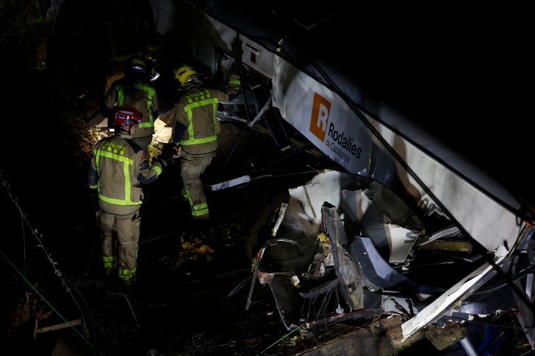 epa12666051 Generalitat's firemen work at the place where a train crashed with a collapsed wall which fell to the via at Gelida city in Barcelona, Spain, 20 January 2026. The train machinist died and fifteen people were injured. EPA/Alberto Estevez