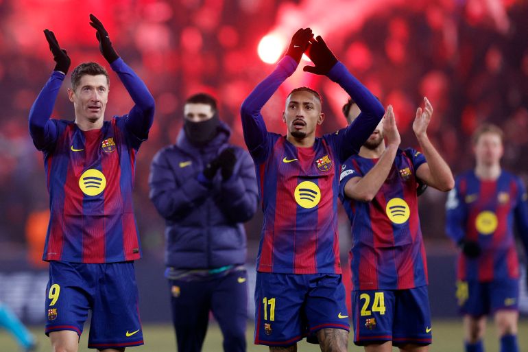Barcelona's Robert Lewandowski and FC Barcelona's Raphinha celebrate after the UEFA Champions League match